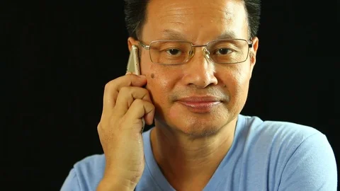 Thai man using smartphone  with black  background, in studio Chiangmai Thailand Stock Footage 111426429