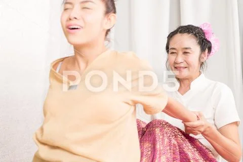 Thai Massage Therapist is hurting a women by stretching her back Stock Photos