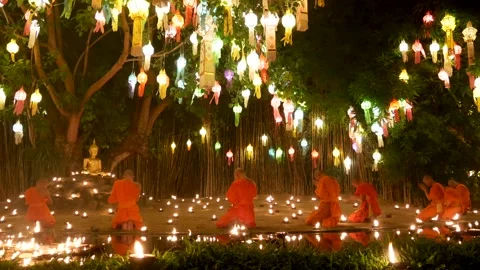Thai Monks sit and bow down to a Buddha image at temple on Yi Peng tradition Stock Footage 256038863