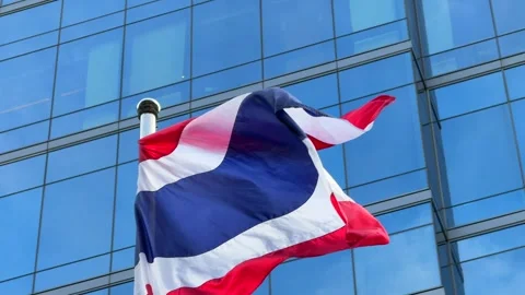 Thai national flags fluttering in the wind against the backdrop of a modern Stock Footage 314354284