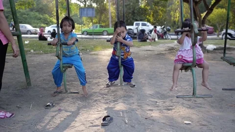 Thai not active children on the swing slowly enjoying swinging in the park Stock Footage 157278911