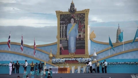 Thai officials salute in front of a large picture of Thai Queen Sirikit Video stock 314774124