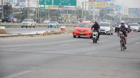 Thai people biking bicycle in race on street highway with traffic road Stock Footage