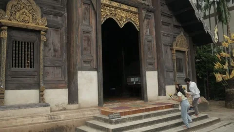 Thai people while walking get into the wooden main hall temple building in .. 動画素材 303134810