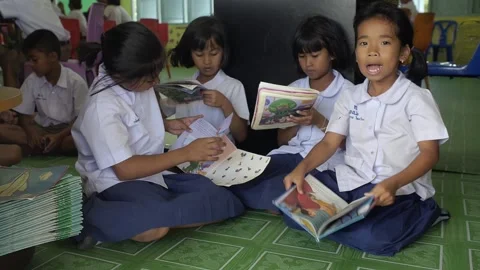 Thai primary students in uniform reading English books happy girl shows a book Stock Footage 156929959