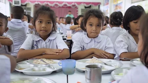 Thai primary students in uniform singing together in the canteen at lunch Stock Footage 156860259