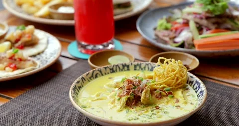 Thai restaurant serving Khao Soi with chicken, fresh salad, festive Stock Footage 311999396