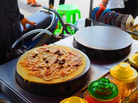 Thai round crape with raisin on hot iron pan, food stall cart Foto stock