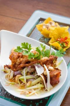 Thai spicy salad with deep fried soft shell crab and sliced green mango, Yum Stock Photos
