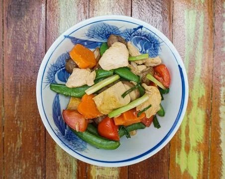 Thai stir-fired chicken: spring onion, tomato, carrot, mushroom, tofu, green pea Stock Photos