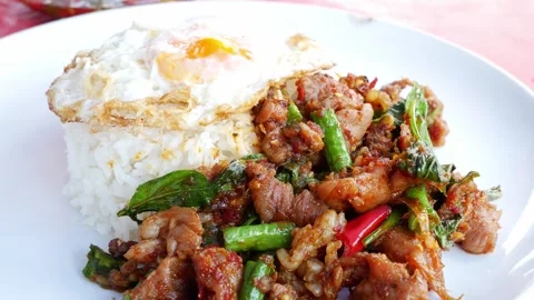 Thai Stir-Fried meet with Red Curry Paste Served Over Rice with Fried Egg Stock Footage 346674240