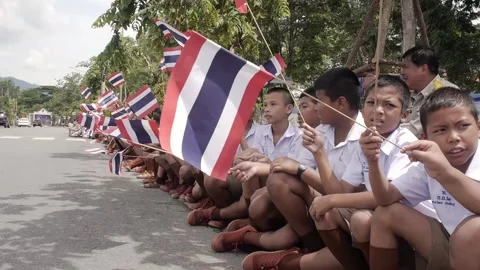 Thai students children boys holding waving Thai flag to greet royals on parade Stock Footage 157698288