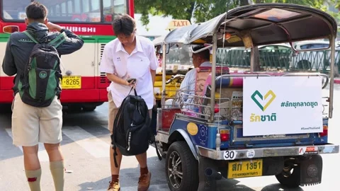 Thai Students Exit Tuk Tuk at Busy Bangkok Bus Stop Stock Footage 323046741