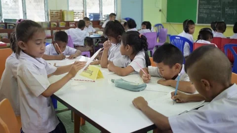 Thai students study English language in classroom writing lesson in test book Stock Footage 156762225