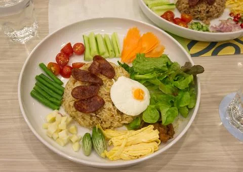 Thai style fried rice with assorted sides and vegetables on the table Stock Photos