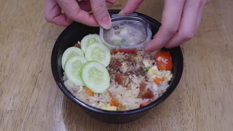 Thai style fried rice in black plastic takeaway bowl with sliced cucumbers .. Stock Footage 337623269