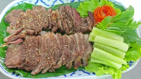 Thai style grilled beef steak with vegetables on a traditional plate. Stock Footage 342394843