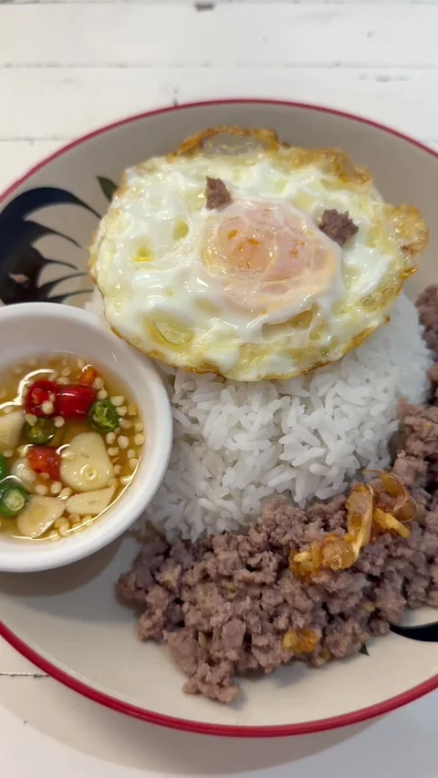 Thai style minced meat served with steamed rice, fried egg, and chili fish sauce Video stock 336598763