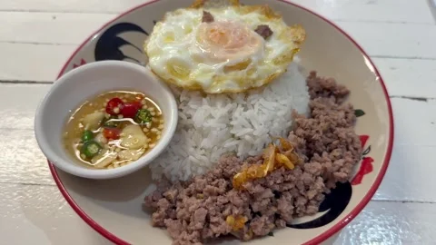Thai style minced meat served with steamed rice, fried egg, and chili fish sauce Stock Footage 336638056