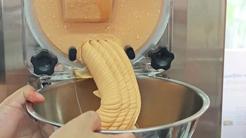 Thai tea gelato dispensing from a batch freezer. Stock-Footage 347632994