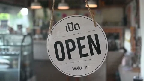 Thai text mean "Open" on vintage sign board hanging on glass door in restaurant Stock Footage 164154304