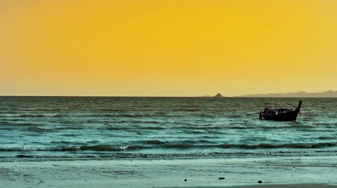 Thai traditional boat with tourists swims to shore of tropical beach at sunse Stock Footage 59774870