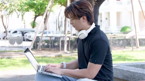 Thai University Student Using Laptop with Headphones Stock Footage 334641054