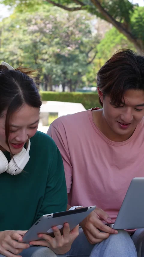 Thai University Students Collaborating Outdoors with Laptop and Tablet Stockbeeldmateriaal 332038086