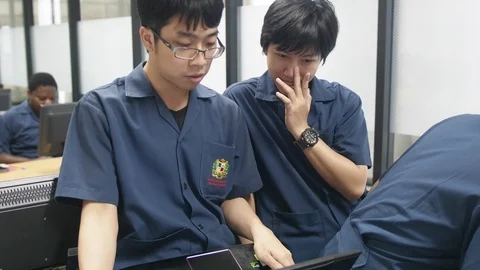 Thai upperclassman teaching freshmen how to code in the computer lab Stock-Footage 98253059