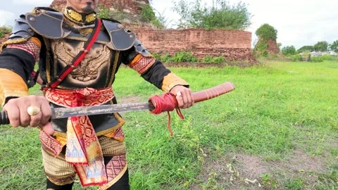 Thai Warrior in Ancient Armor Drawing Sword at Ayutthaya Ruins Stock Footage 343808627