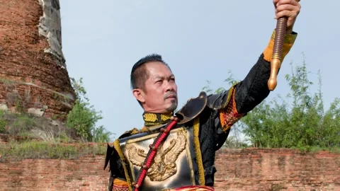 Thai Warrior in Ancient Armor Performing Sword Skills at Historical Ruins Stock Footage 338319701