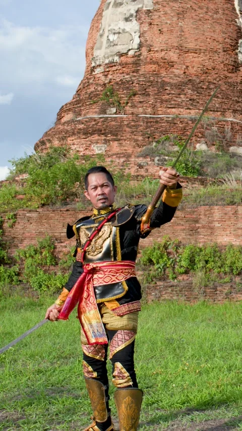 Thai Warrior in Ancient Armor Performing Sword Skills at Historical Ruins Stock Footage 341075949