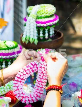Thai woman making a tradition Thai flowers garland.. Stock Photos