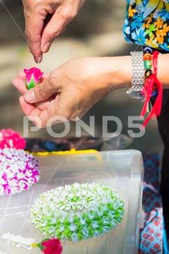 Thai woman making a tradition Thai flowers garland.. Stock Photos