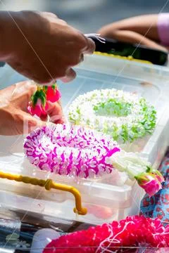 Thai woman making a tradition Thai flowers garland.. Stock Photos