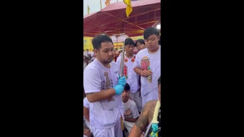 Thailand: Devotee has cheeks pierced with bamboo umbrellas at festival in... Stock Footage 320637452