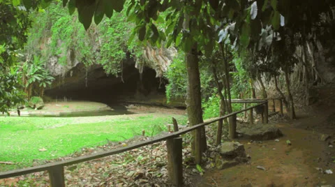 Tham Loed cave sign to cave entrance pan Stock Footage 24269384