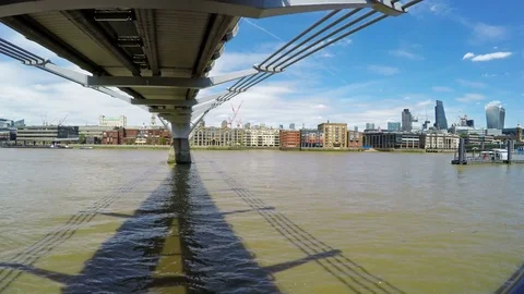 Thames River flowing under Millennium Bridge on a sunny day in London, England Stock Footage 79507962