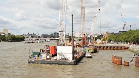 Thames Tideway Scheme under construction with heavy machinery on barges on river Stock Footage 93798868