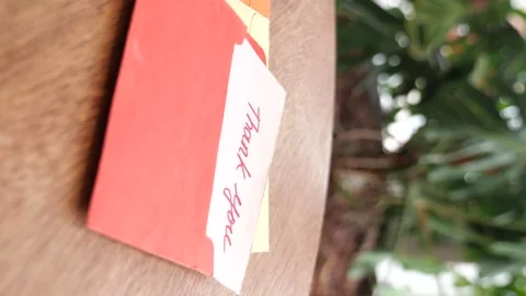 Thank you card with red envelope on wooden table dynamic motion. Stock Footage 332034443