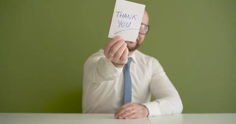 Thank You  - A man presents a note with the word Stock Footage 267088575