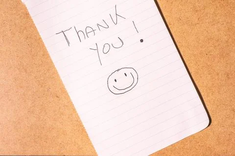 A Thank you note on a brown background. Stock Photos