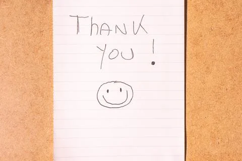 A Thank you note on a brown background. Stock Photos