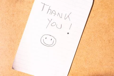 A Thank you note on a brown background. Stock Photos