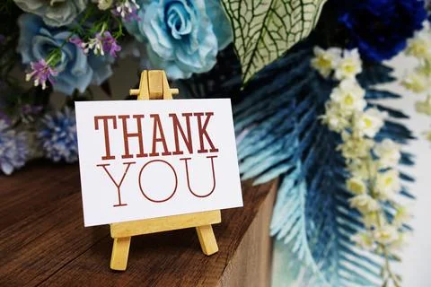 Thank you text write on paper card with wooden easel and flowers decoration.. Stock Photos