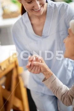Thankful aged woman shaking hand of caregiver Stock Photos