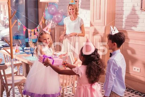 Thankful girl smiling to her friends while getting presents from them Stock Photos