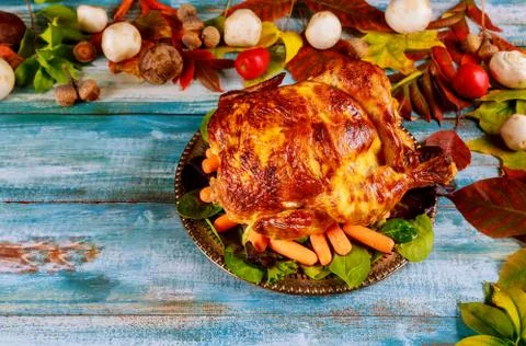 Thanksgiving day dinner table setting with whole roasted chicken on plate Stock Photos