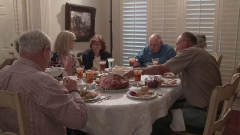 Thanksgiving dinning table as elderly friends dine and converse, 4K. Stock Footage 81645836
