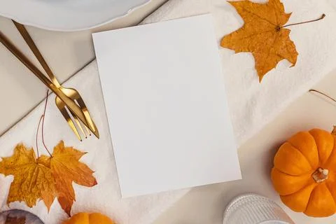 Thanksgiving invitation mock-up, fall table setting with leaves and blank p.. Stock Photos